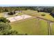 Aerial view of a horse farm with riding arenas, green pastures and multiple stables at 113 High Hammock Villas, Seabrook Island, SC 29455