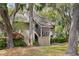 Inviting condo with covered stairwell entrance amidst palm trees and vibrant azalea bushes at 113 High Hammock Villas, Seabrook Island, SC 29455