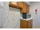 Kitchen features a microwave, wood cabinets, and floral wallpaper at 113 High Hammock Villas, Seabrook Island, SC 29455