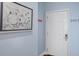 Shot of the light blue hallway with a picture of a frog and a white entry door to the unit at 114 W Arctic Ave # B302, Folly Beach, SC 29439