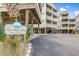 Pier Pointe Villas building with multiple balconies, covered parking and beautifully landscaped grounds at 114 W Arctic Ave # B302, Folly Beach, SC 29439