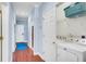Hallway featuring hardwood floors, a laundry closet with a washer and dryer, and neutral paint at 114 W Arctic Ave # B302, Folly Beach, SC 29439