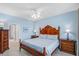 Comfortable bedroom features a decorative wood bed frame, ceiling fan, and access to an ensuite bathroom at 114 W Arctic Ave # B302, Folly Beach, SC 29439