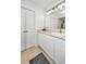 Bathroom vanity featuring white cabinets, a gold faucet, a large mirror and double doors at 1209 River Rock Rd, Hanahan, SC 29410