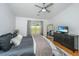 Bright bedroom featuring a queen bed, ceiling fan, hard floors, and a tv on a black dresser at 1209 River Rock Rd, Hanahan, SC 29410