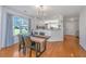 Bright dining area featuring wood floors, modern light fixture, and views into the kitchen at 1209 River Rock Rd, Hanahan, SC 29410