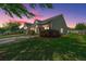 Charming single-story home with manicured lawn and mature landscaping at sunset at 1209 River Rock Rd, Hanahan, SC 29410