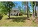 Expansive backyard features mature trees, a screened in porch and a well-manicured lawn, perfect for outdoor activities at 1325 Wannamaker Ave, Summerville, SC 29485