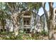 Exterior of a condo complex showcasing stairs leading to units, surrounded by lush greenery and trees at 1342 Pelican Watch Villas, Seabrook Island, SC 29455