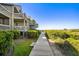 Scenic boardwalk leading to the beach, surrounded by lush greenery and beautiful landscaping at 1342 Pelican Watch Villas, Seabrook Island, SC 29455