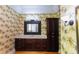 Tropical bathroom featuring vibrant wallpaper, vanity and a built-in storage cabinet at 1392 Eden Rd, Awendaw, SC 29429