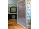 Tropical bathroom featuring vibrant wallpaper and a sleek glass-enclosed shower at 1392 Eden Rd, Awendaw, SC 29429