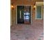 Exterior view of entry with sidelight window, showcasing a brick-paved porch at 1392 Eden Rd, Awendaw, SC 29429
