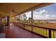 Inviting screened porch with wood floors, railing, and picturesque outdoor views at 1392 Eden Rd, Awendaw, SC 29429