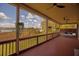Inviting screened porch with wood floors, railing, and picturesque outdoor views at 1392 Eden Rd, Awendaw, SC 29429