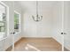 Sunlit dining room featuring hardwood floors, white wainscoting, modern chandelier, and ample natural light at 1409 Lieben Rd, Mount Pleasant, SC 29466