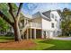 Exterior showcasing elevated home with a screened-in porch, deck, and lush landscaping at 1409 Lieben Rd, Mount Pleasant, SC 29466