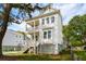 Charming two-story white home featuring double porches, a manicured lawn, and mature trees at 1409 Lieben Rd, Mount Pleasant, SC 29466