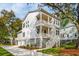 Stunning two-story white home with double porches, showcasing a modern design and well-maintained landscaping at 1409 Lieben Rd, Mount Pleasant, SC 29466