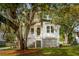 Inviting two-story home featuring a classic exterior, dual porches, and mature trees draped with Spanish moss at 1409 Lieben Rd, Mount Pleasant, SC 29466