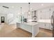Spacious modern kitchen with white cabinets, stainless steel appliances, a large kitchen island and view to the staircase at 1409 Lieben Rd, Mount Pleasant, SC 29466