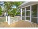 Inviting screened-in porch with wood flooring and a white railing overlooking the backyard at 1409 Lieben Rd, Mount Pleasant, SC 29466
