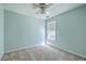 Bedroom with a light blue painted wall, ceiling fan, and a large window at 1436 Harbor Mist Ct, Charleston, SC 29492