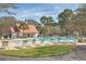 Exterior view of a community pool and amenity center surrounded by lounge chairs, trees, and green grass at 1436 Harbor Mist Ct, Charleston, SC 29492