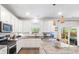 Open kitchen boasts white cabinetry, stainless steel appliances, granite counters, and a seamless flow to the living area at 149 Caleb Ct, Ladson, SC 29456