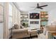 Inviting living room featuring ceiling fan, a fireplace, a sofa, an ottoman, and stylish built-in shelves at 149 Caleb Ct, Ladson, SC 29456