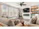 Open-concept living room with neutral decor, a ceiling fan, a fireplace, and built-in shelves at 149 Caleb Ct, Ladson, SC 29456