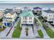 Aerial view of lovely home with green roof, multiple balconies and driveway landscaping at 1681 E Ashley Ave # A, Folly Beach, SC 29439