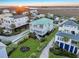 Aerial view of charming home with green roof, dual balconies, pretty landscaping, and great sunset at 1681 E Ashley Ave # A, Folly Beach, SC 29439