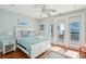 Bright bedroom features a ceiling fan, wooden floors, and access to a private balcony overlooking the ocean at 1681 E Ashley Ave # A, Folly Beach, SC 29439