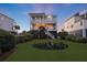 Exterior of a two-story beach house with a manicured lawn and garden at 1681 E Ashley Ave # A, Folly Beach, SC 29439