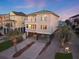 Beautiful beach home with a multi-story balcony, stilt foundation, and tropical landscaping at sunset at 1681 E Ashley Ave # A, Folly Beach, SC 29439