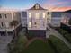A light-blue stilt beach house is perfectly positioned with ocean views from the upper balcony at 1681 E Ashley Ave # A, Folly Beach, SC 29439