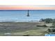 Scenic coastal view featuring a marsh landscape with a historic lighthouse, nestled near the ocean's horizon at low tide at 1681 E Ashley Ave # A, Folly Beach, SC 29439