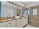 Modern bathroom featuring double vanity with granite counters, large mirror, tile shower, and glass door at 1681 E Ashley Ave # B, Folly Beach, SC 29439
