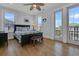 Light-filled bedroom with hardwood floors, balcony access, ceiling fan, and calming neutral decor at 1681 E Ashley Ave # B, Folly Beach, SC 29439