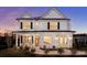 Elegant two-story white home with black shutters, a welcoming porch and a well-manicured lawn at 177 Cantona Dr, Summerville, SC 29483