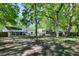 A spacious backyard featuring mature trees, playground set and screened in porch at 1812 Overrun St, Charleston, SC 29414