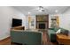 Bright living room featuring stone fireplace, hardwood floors, and green sofas at 1812 Overrun St, Charleston, SC 29414