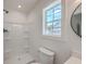 Bright bathroom featuring a white shower, toilet, and vanity next to a window with natural light at 1932 Staffwood Rd, Johns Island, SC 29455