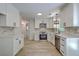 Bright kitchen features white cabinets, stainless steel appliances, stone countertops and modern light fixtures at 1932 Staffwood Rd, Johns Island, SC 29455