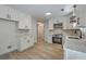 Bright kitchen features white cabinets, stainless steel appliances, stone countertops and modern light fixtures at 1932 Staffwood Rd, Johns Island, SC 29455
