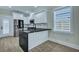 Modern kitchen with white cabinets, stainless steel appliances, black countertops, and luxury vinyl flooring at 1956 Beech Ave, North Charleston, SC 29405