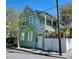 Charming two-story home with a balcony, white picket fence, and lush greenery at 2 Hanover St, Charleston, SC 29403