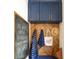 Stylish entryway with blue cabinets, wood paneled wall, and chalkboard at 2 Live Oak Ave, Charleston, SC 29407