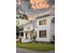 Beautiful home featuring white siding, black windows, covered porch, and manicured landscaping at 2 Live Oak Ave, Charleston, SC 29407